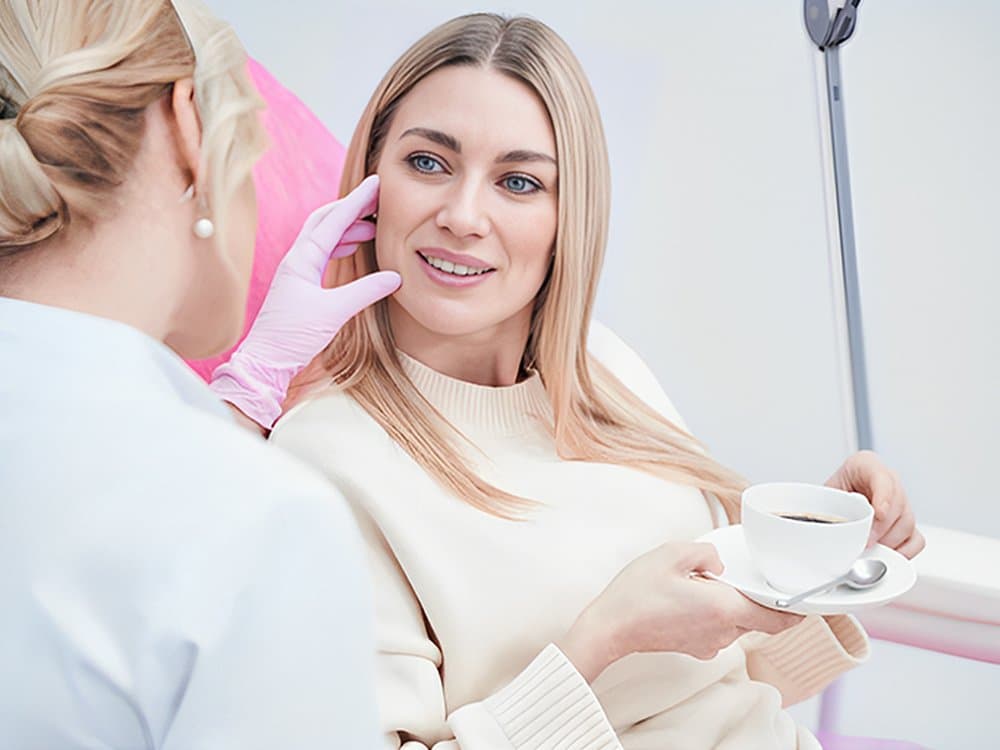 Practitioner in consultation with a client in a treatment chair